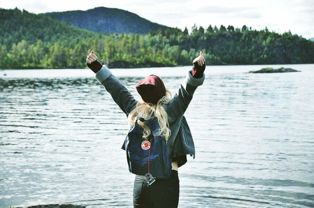 Young girl celebrating a win facing a lake