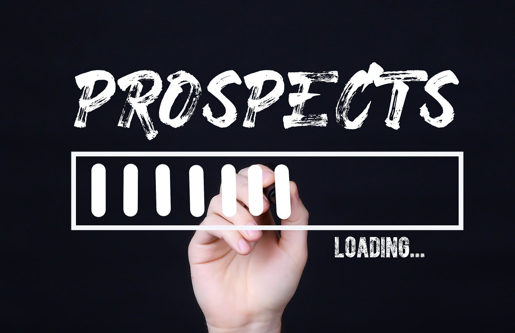 A hand is writing prospects with white on the screen