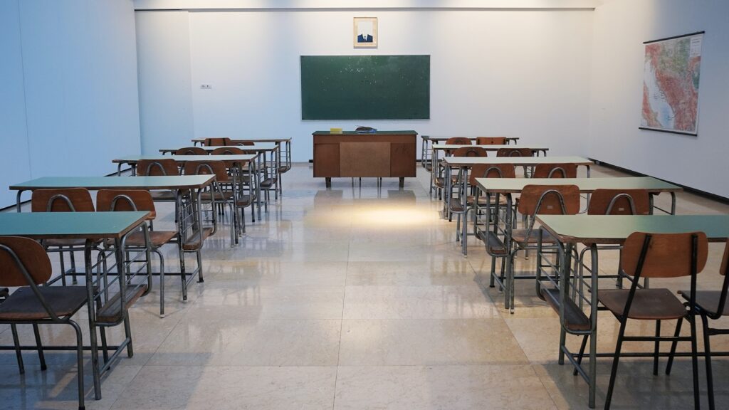 Empty classroom with wooden chairs and blackboard
