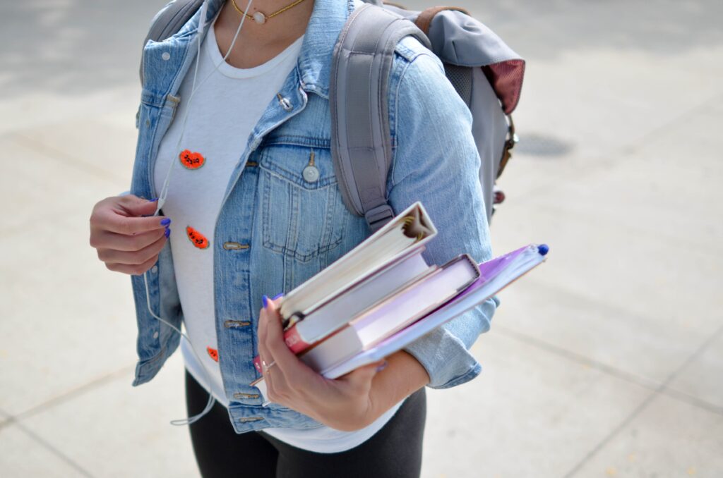 Woman wearing blue denim holding books